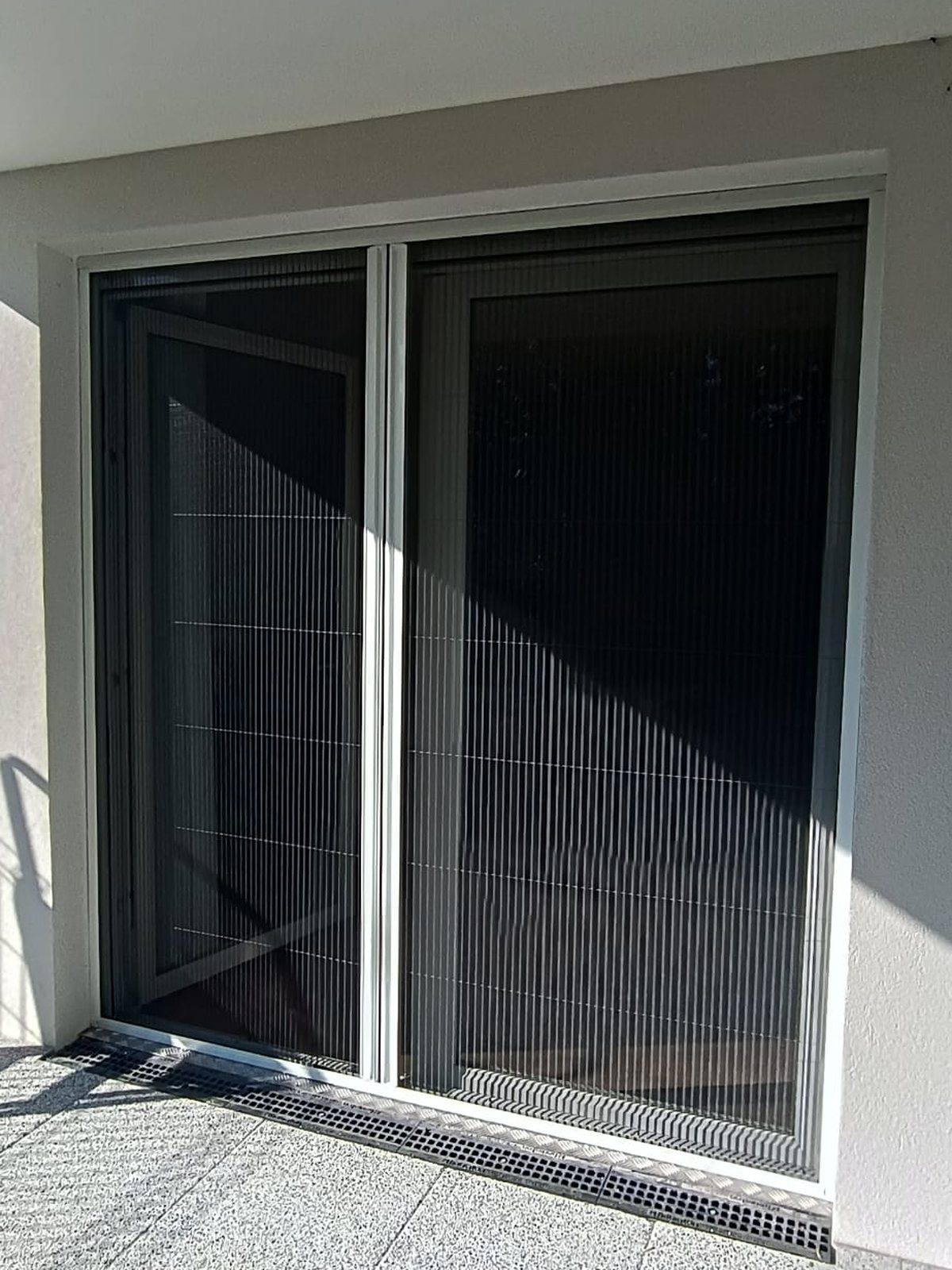 Gros plan d'une moustiquaire coulissante sur baie vitrée